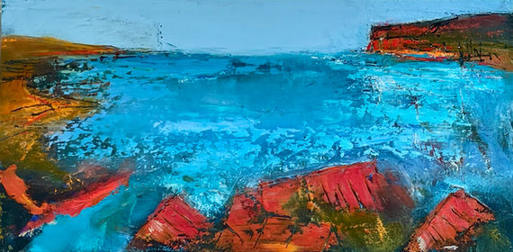 A dramatic blue sea is surrounded by vibrant orange shorelines and promontories.