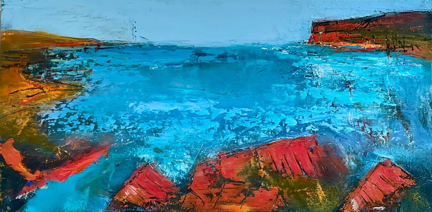 A dramatic blue sea is surrounded by vibrant orange shorelines and promontories.