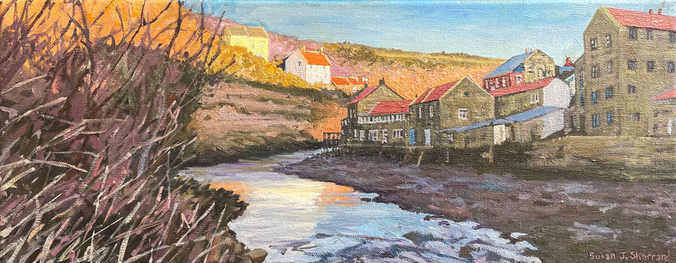 A panoramic morning scene of Staithes cottages silhouetted against the sunlit Cowbar gorge from a low viewpoint.