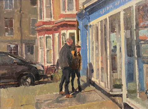 Visitors admiring the paintings in Staithes Gallery window.