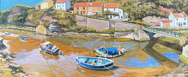 A dramatic panoramic view looking over Staithes Beck and boats, the golden sandstone cliff above reflecting in the water.