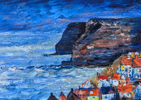 A nocturnal scene looking over Staithes village to the cliffs in shadow beyond.