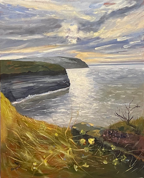 A sweeping view looking up the coastline from Cowbar nab with the sea sparkling in the hazy sunshine.