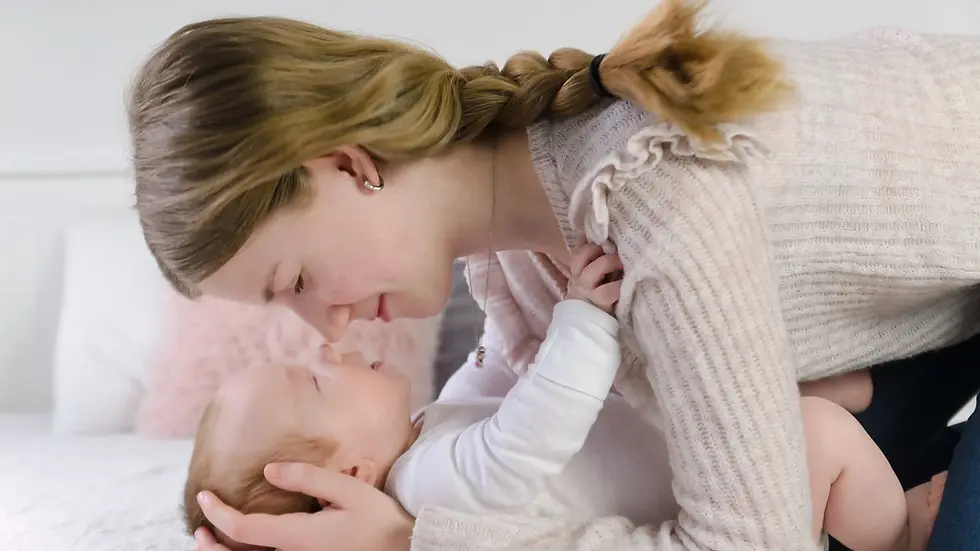 Herzliche Geschwistermomente im Fotostudio Borken – große Schwester kuschelt liebevoll mit schlafendem Baby.