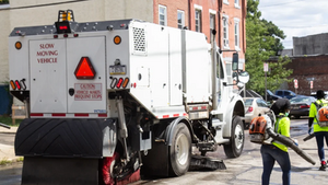 A commercial sweeper truck clearing debris from a large parking lot in Nebraska to improve curb appeal and pavement health.