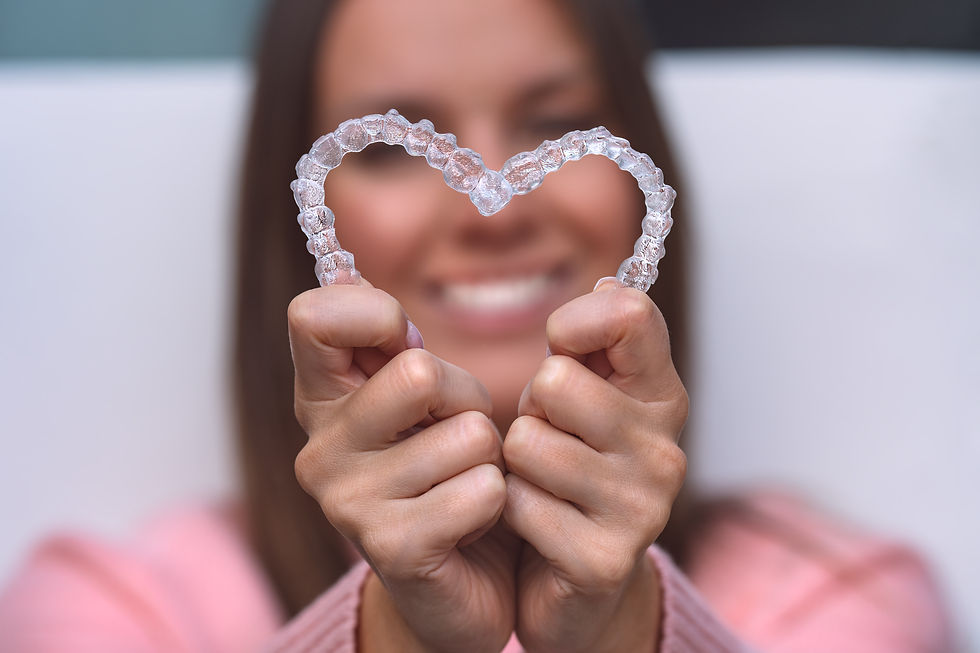 A women with clear aligners shaped like a heart showing off her teeth.