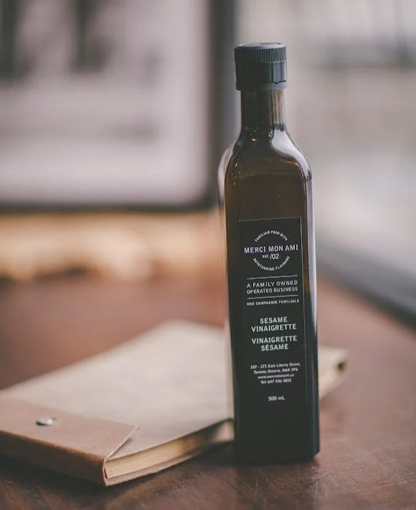 Merci Mon Ami Sesame Soy Vinaigrette bottle on rustic table