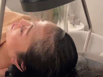頭浸浴ヘッドスパを受ける女性