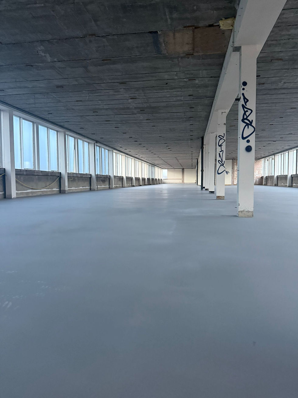 Wide angle view of construction site showing partially screeded floors and materials ready for dry lining