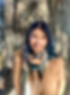 Photo of smiling 29 year old Shruti, standing at the trunk of a large tree
