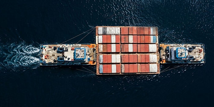 Top view of container barge with tugboats in maritime transport operation