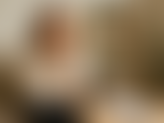 Noor naine selge pilguga istumas laua taga, märkmik ees, valgusküllases teraapiaruumis, sümboliseerides selgust ja professionaalsust.