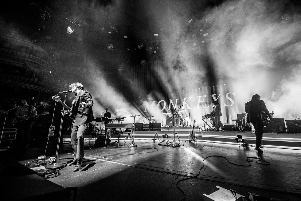 Fotografía en blanco y negro de la banda Arctic Monkeys tocando en vivo sobre el escenario del Royal Albert Hall de Londres en junio de 2018
