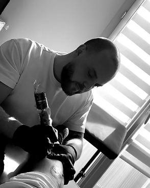 Photo du tatoueur Kroztibat dans son studio en train de réaliser un tatouage