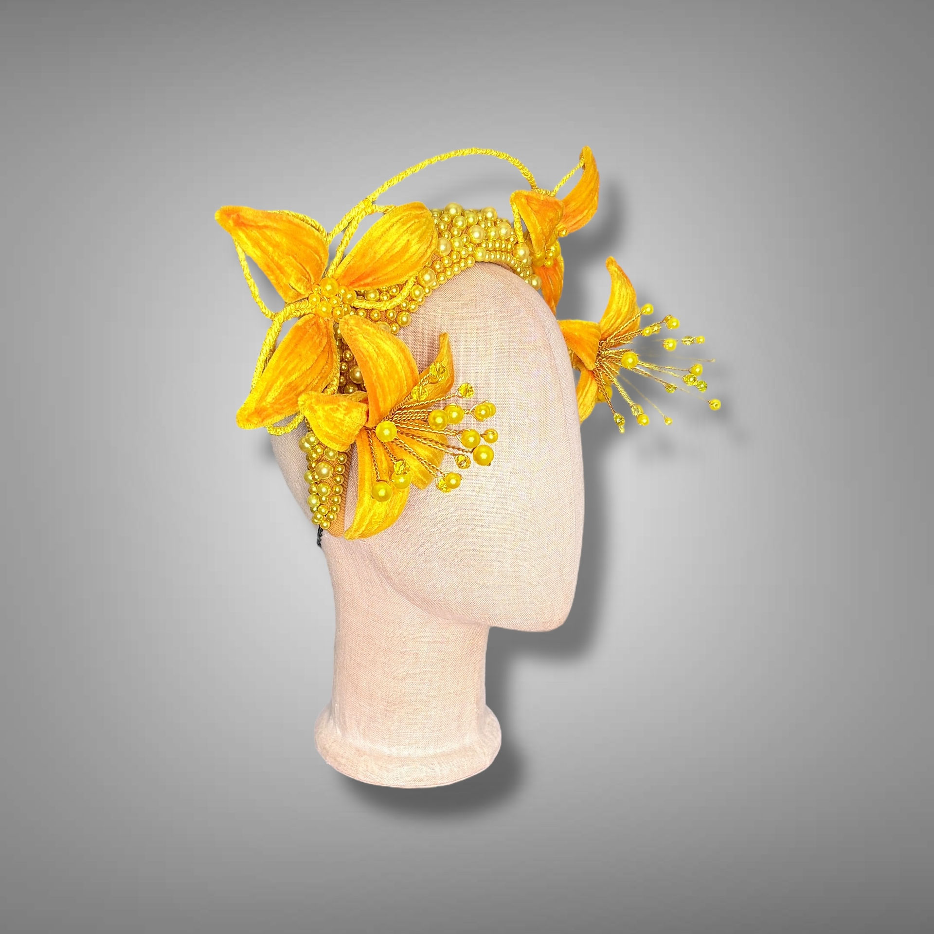 A yellow and saffron luxury headpiece with a velvet inspidered spider lily on each side of head