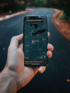 Close up shot of a person using their phone to look at a map of locations for Lifetime Quality Roofing