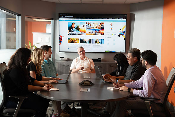 Employees gathered around conference table listening to presentation