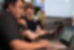 Two employees staring down at one laptop