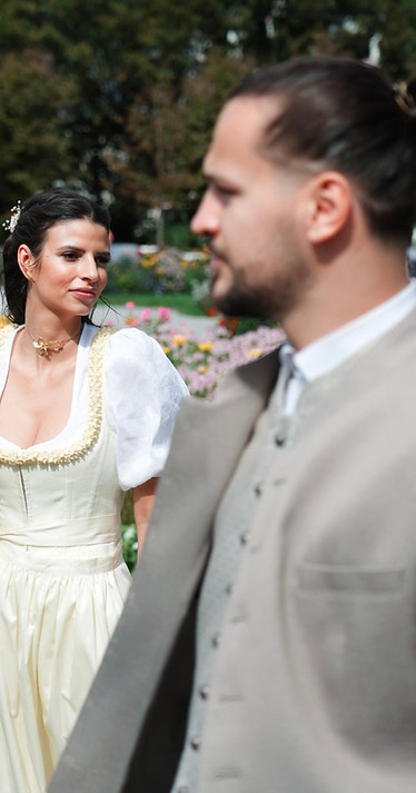 Eigentümerpaar in traditioneller Kleidung spaziert durch den Kurpark in Bad Ischl