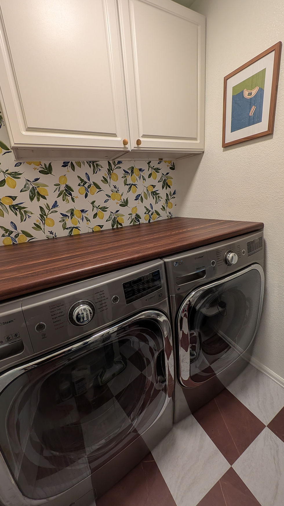 Bright paint, playful wallpaper, warm wood tones, and polished brass details turned this laundry room into a clean, cheerful, and inviting space.