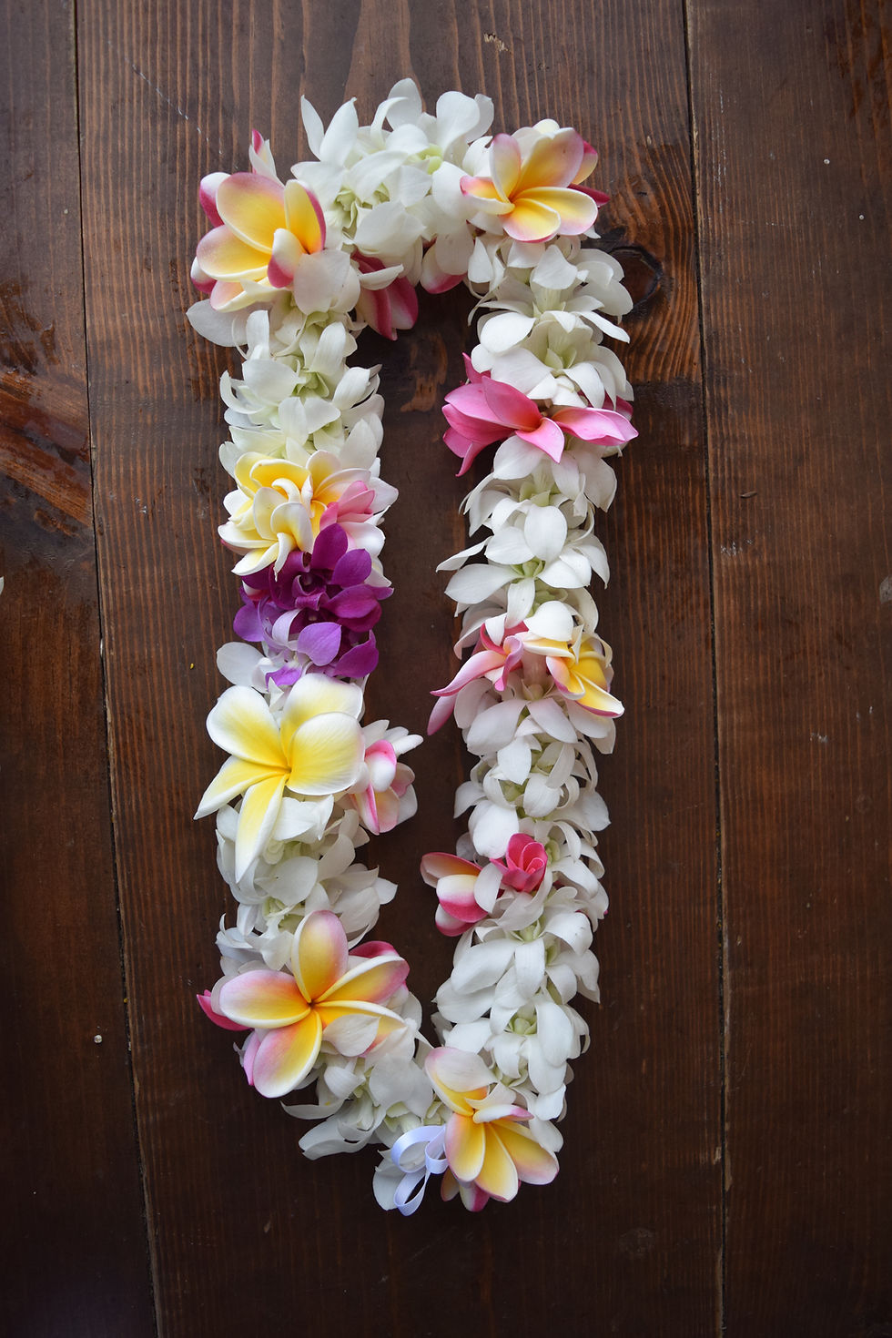 rope-style white orchid with tucks of plumeria lei
