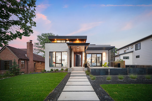 A layered façade of steel, wood, and stucco brings texture and rhythm to the street presence.