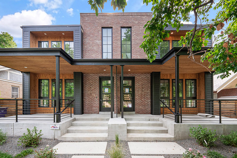 The modern duplex façade features warm brick, clean lines, and well-balanced proportions.