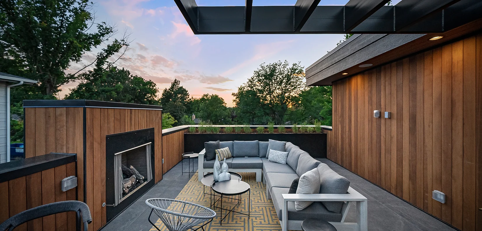 An outdoor lounge space with fireplace provides warmth and ambiance just off the upper-level retreat.