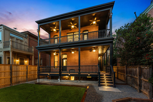 Dual wraparound porches create both functional outdoor space and visual rhythm across the rear elevation.