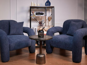 Cozy blue chairs, table and mic in Dubai podcast studio, a stylish podcast studio Dubai setup.