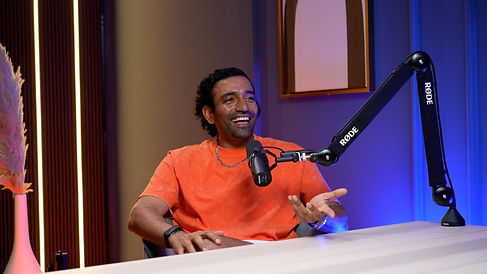 Male guest in orange shirt mid-sentence during Dubai podcast studio session podcast studio Dubai