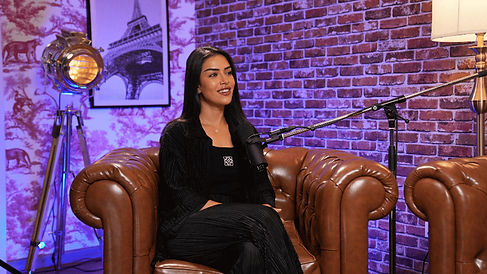 Female host on brown leather sofa setup at Dubai podcast studio podcast studio Dubai environment