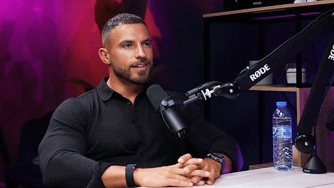 Serious guest with dark shirt on neon setup podcast studio Dubai recording at Dubai podcast studio
