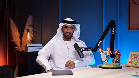 Traditional guest in white kandura with toy figurines recorded at Dubai podcast studio podcast
