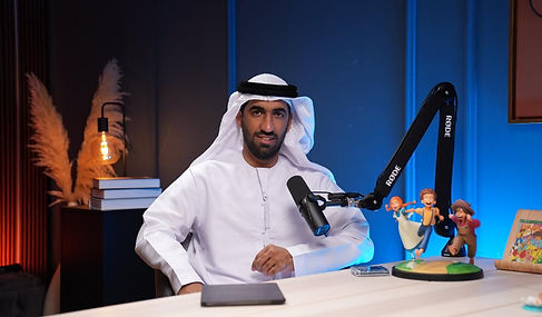 Traditional guest in white kandura with toy figurines recorded at Dubai podcast studio podcast
