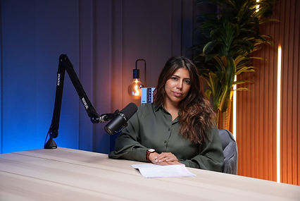 Calm female host with green shirt on elegant studio background Dubai podcast studio shoot podcast studio Dubai