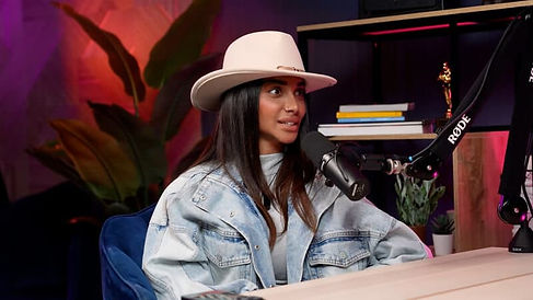 Stylish female guest with white hat in pink neon podcast setup Dubai podcast studio podcast studio Dubai