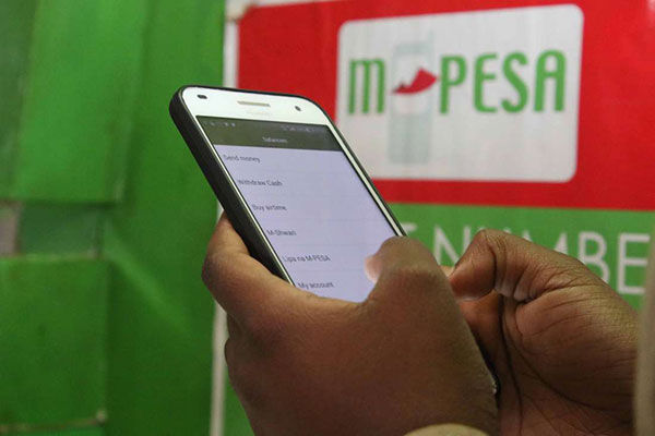 A Safaricom customer using M-PESA services/ PHOTO/ COURTESY