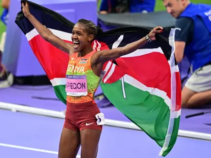 Kenya’s Faith Kipyegon celebrates with the national flag after winning gold in the women’s 1500m final during the Paris 2024 Olympic Games at Stade de France in Saint-Denis, north of Paris, on August 10, 2024. PHOTO: MARTIN BERNETTI/AFP