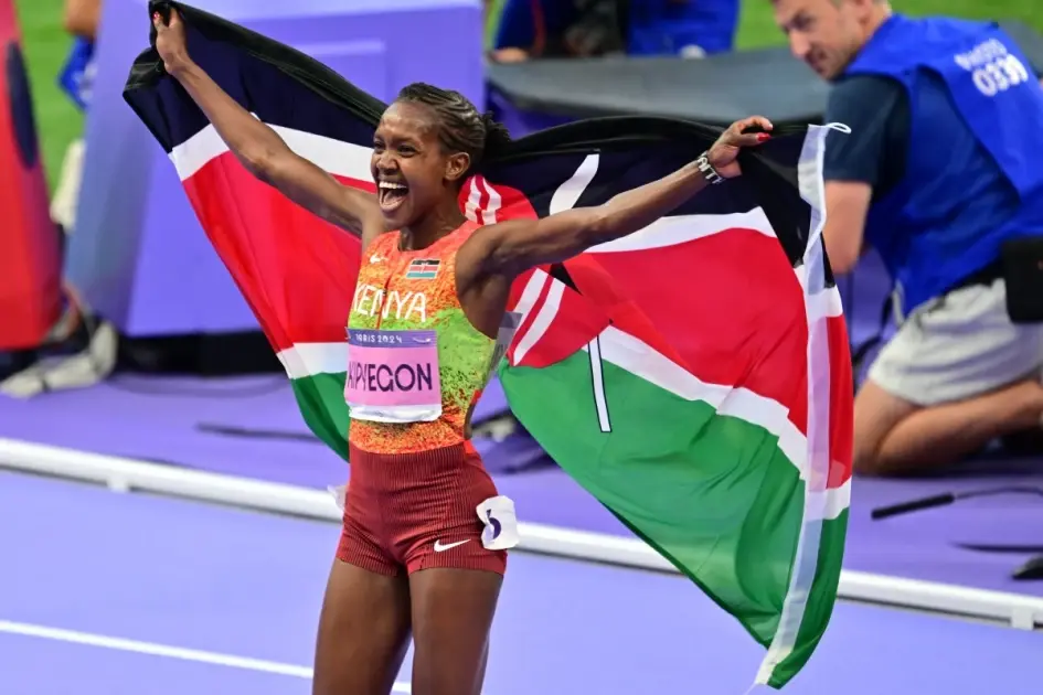 Kenya’s Faith Kipyegon celebrates with the national flag after winning gold in the women’s 1500m final during the Paris 2024 Olympic Games at Stade de France in Saint-Denis, north of Paris, on August 10, 2024. PHOTO: MARTIN BERNETTI/AFP