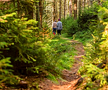 two people walking in the woods