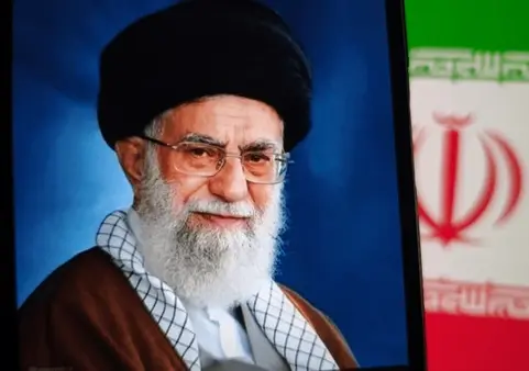 Khamenei next to Iranian flag