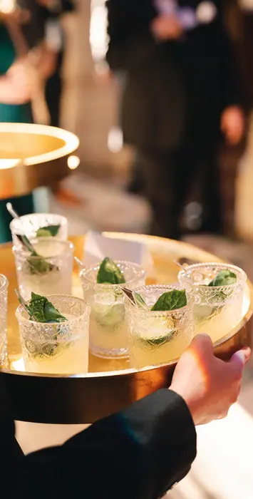 Server carrying tray of luxury cocktails