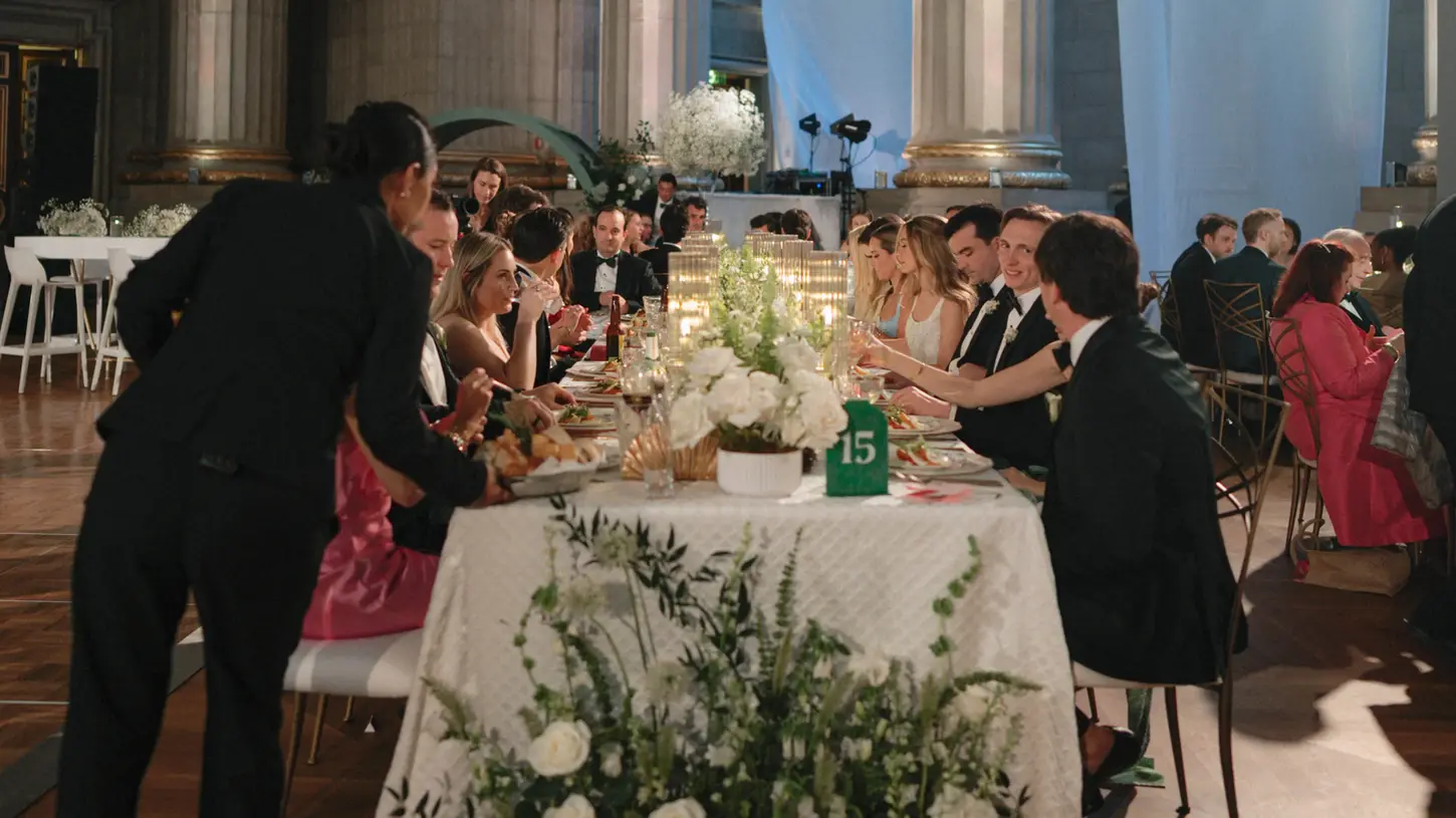 Guests being served dinner at wedding reception. 