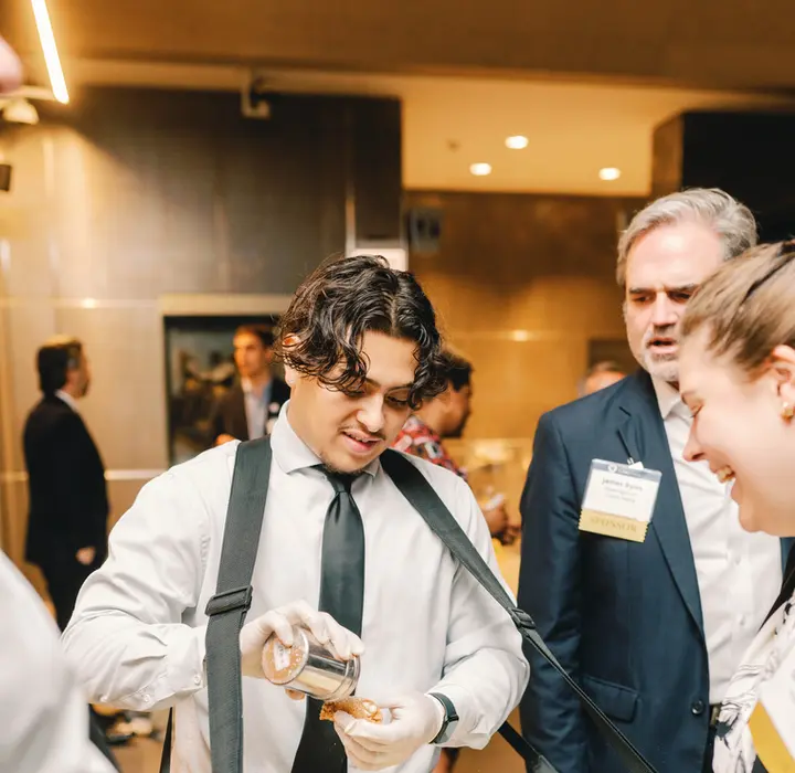 Server making cannolis for event guests