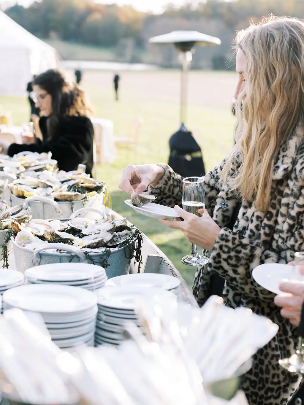 girl grabbing fresh oysters from bar