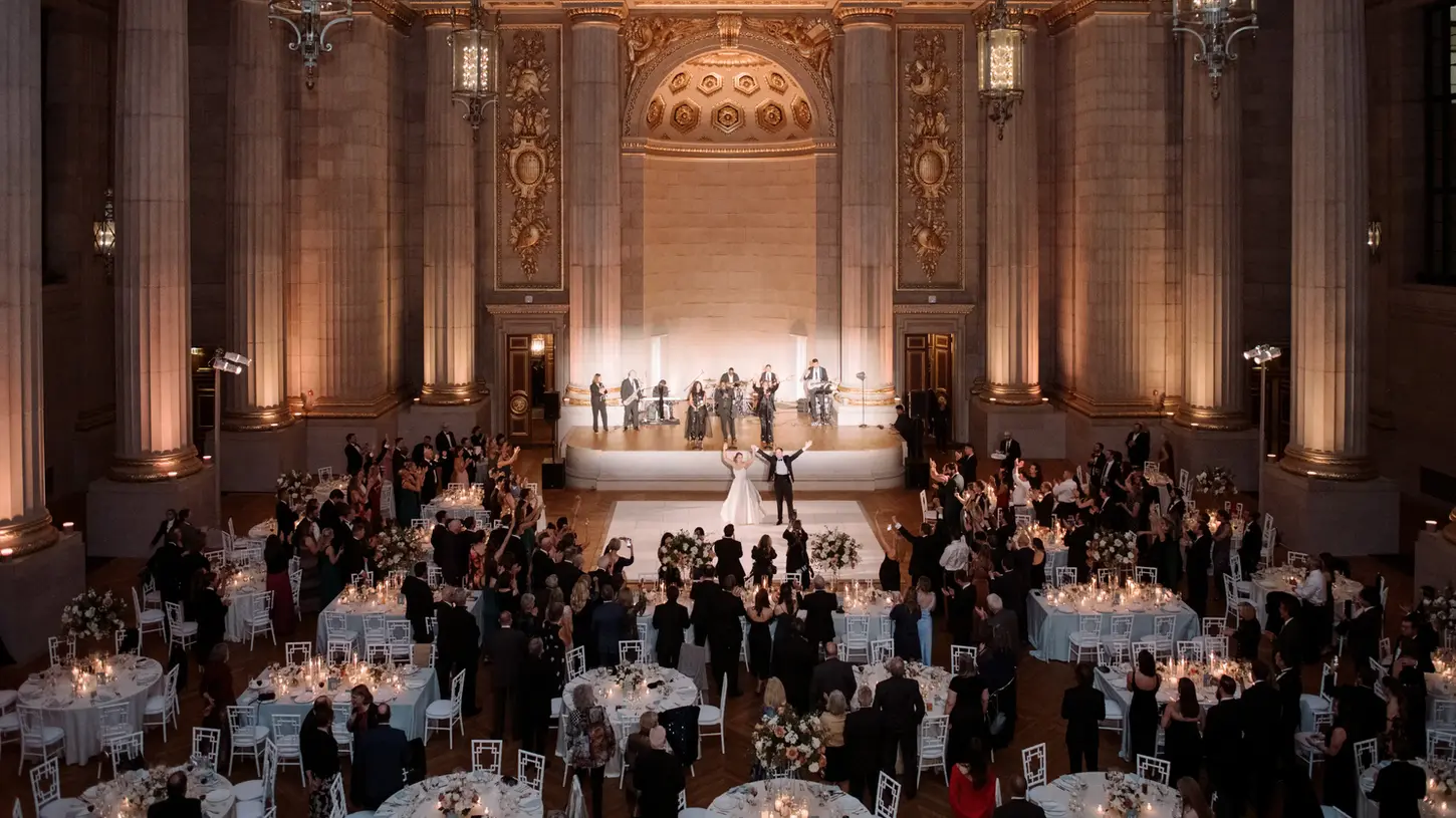Bride and groom on the dance floor at their wedding reception surrounded by friends and family members