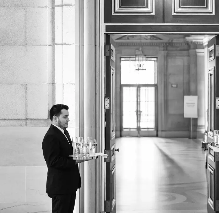 Servers offering welcome drinks to guests upon arrival