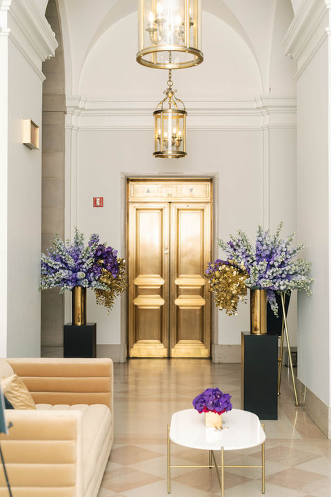 A view of the golden elevator doors and modern lounge furniture on the third floor foyer at the Andrew W. Mellon Auditorium