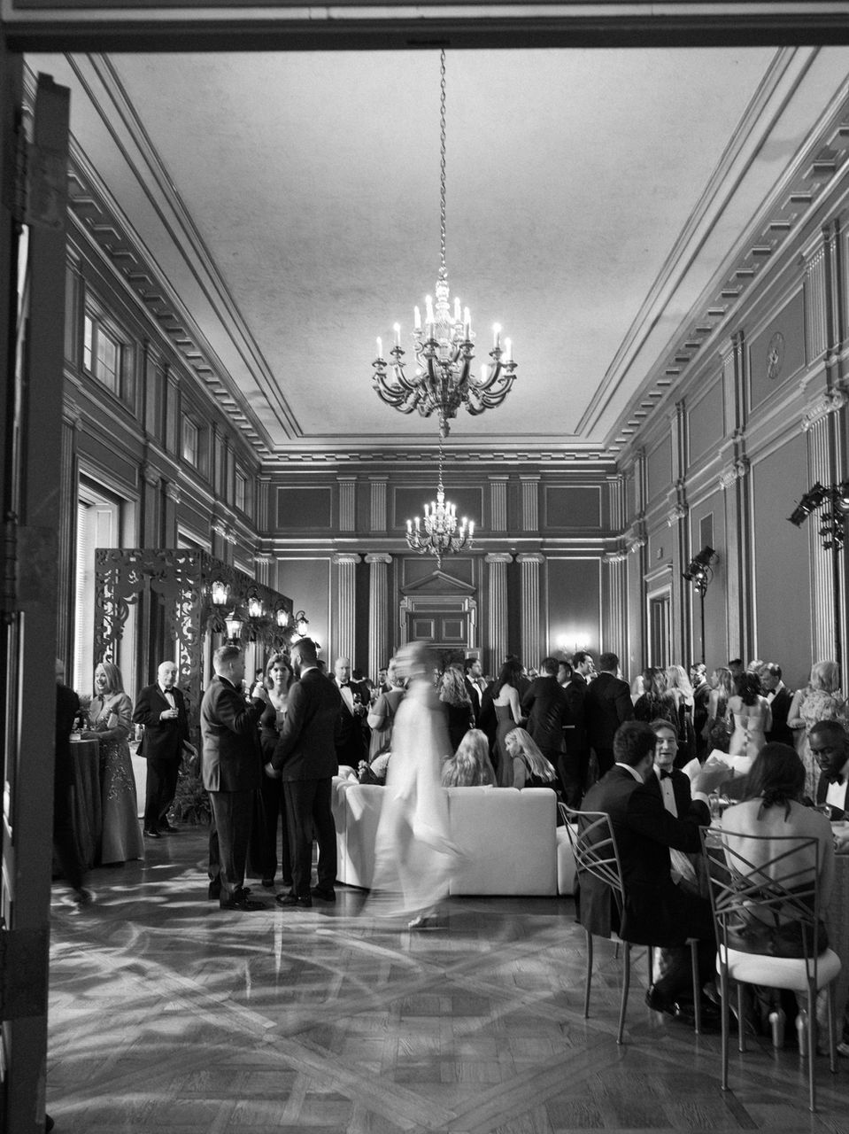 A dynamic motion-blur image of guests enjoying cocktail hour in the green rooms at the Andrew W. Mellon Auditorium